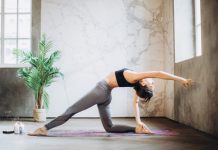 Woman in Gray Leggings and Black Sports Bra Doing Yoga on Yoga Mat